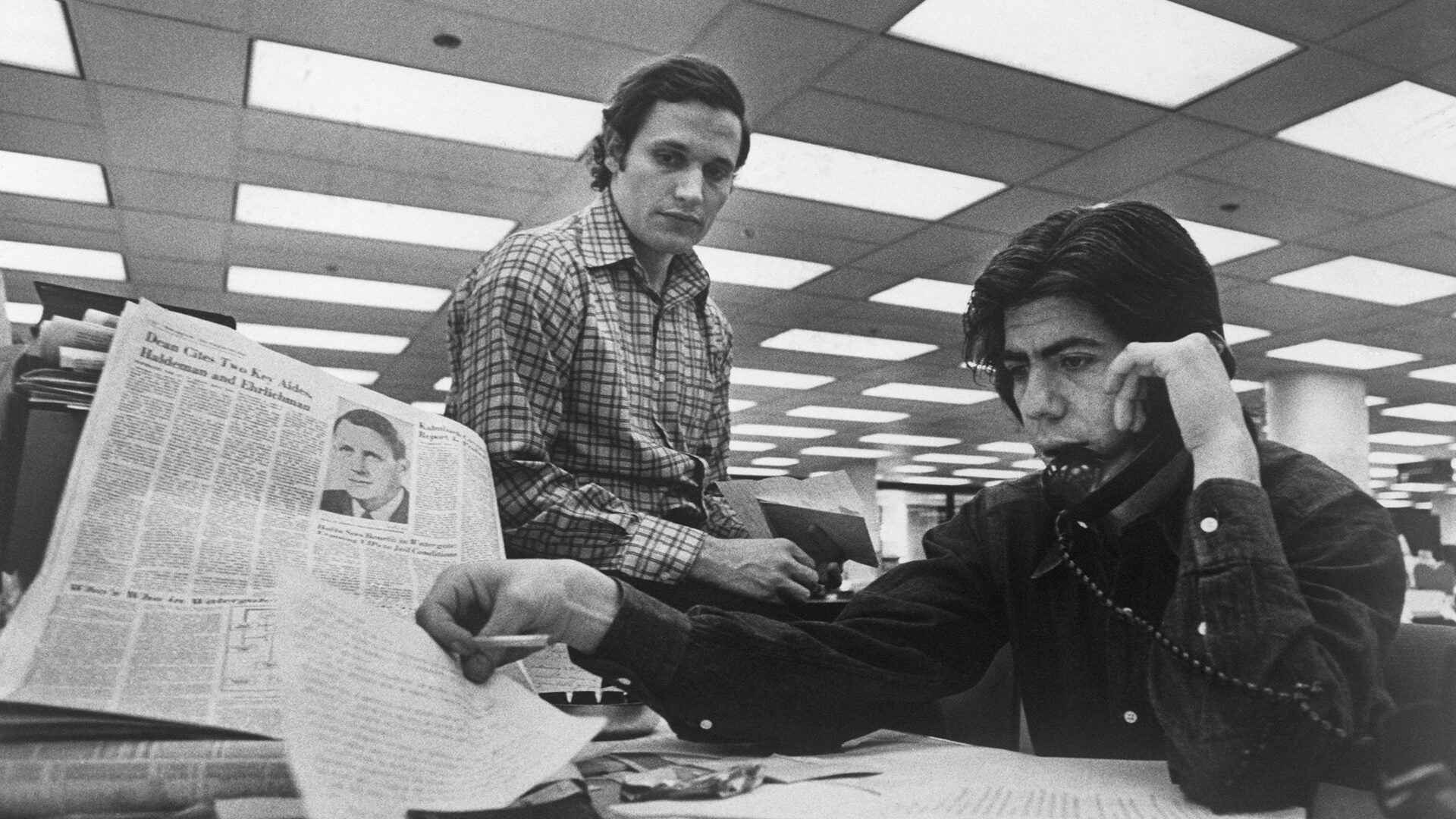 Bob Woodward (left) and Carl Bernstein, Washington Post staff writers who have been investigating the Watergate case, at their desk in the Post.