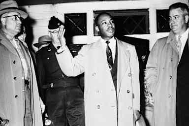 The Rev. Martin Luther King Jr. addresses a crowd from his front porch, at his home in Montgomery, Ala., on Jan. 30, 1956, after it was bombed.