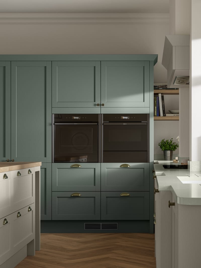 A contemporary kitchen with green and cream cabinets in Ambleside, featuring a Shaker-style design.