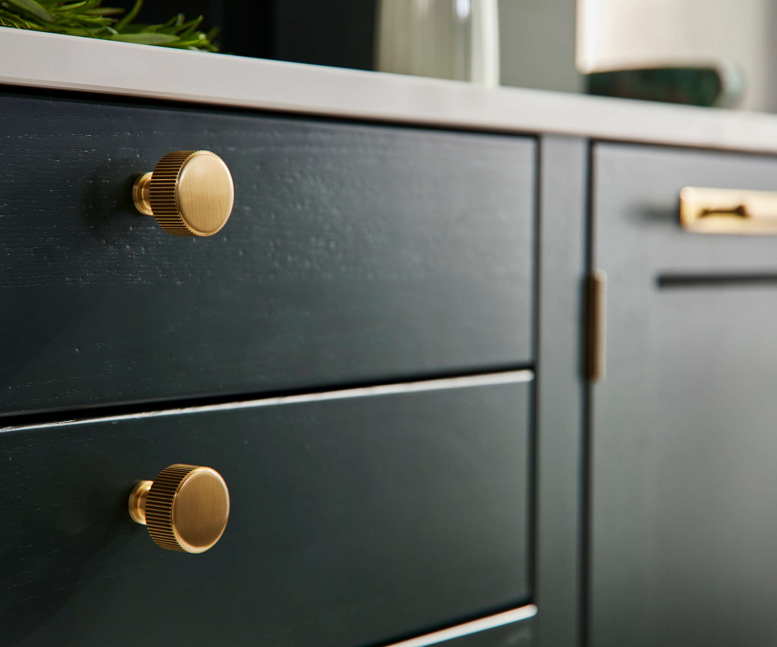 Ludlow, a traditional Shaker-style kitchen range in the shade Arboretum Green, combined with brass handles and knobs.