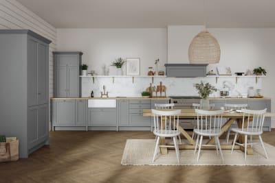 A contemporary home with a grey kitchen featuring white cabinets and wooden floors.