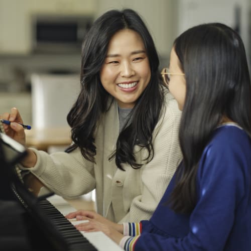 Person teaching piano to student