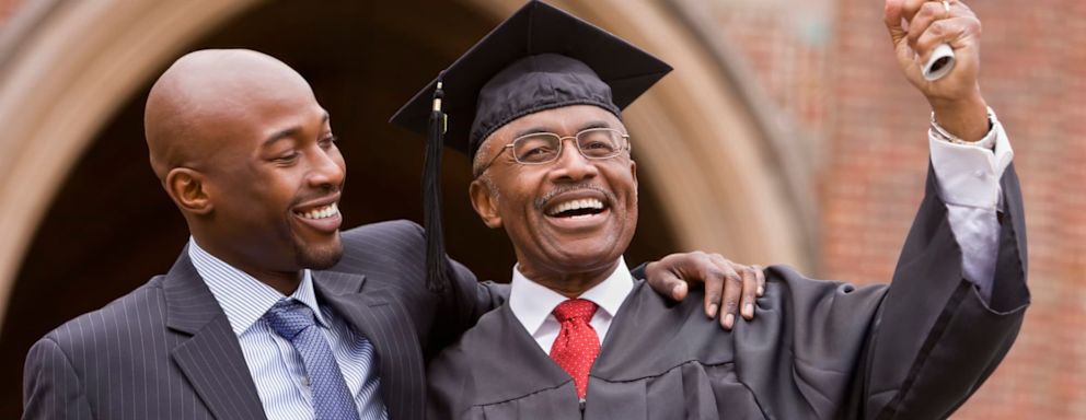 African man hugging graduate father