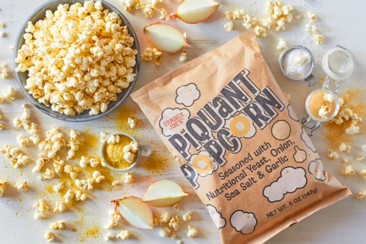 A bag of popcorn with popcorn scattered around it