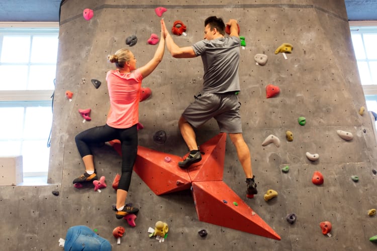 A couple climbing on an indoor rock climbing wall