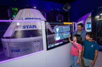 Vater und 2 Kinder bei der Besichtigung der Starlink-Attraktion