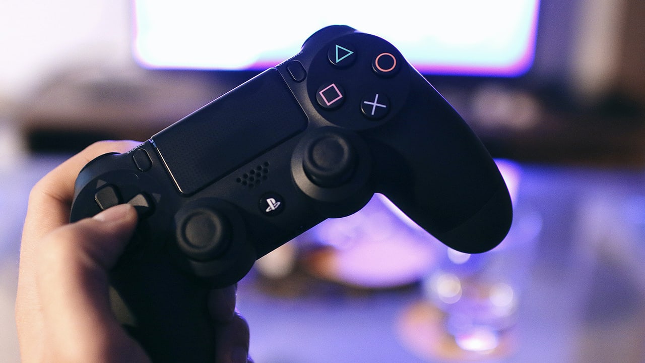 Close photo of hand holding a Playstation controller 
