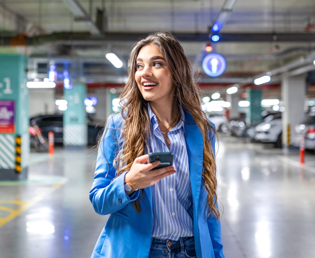 A person walking around a parking lot pleased that she had a great parking experience with SpotHero