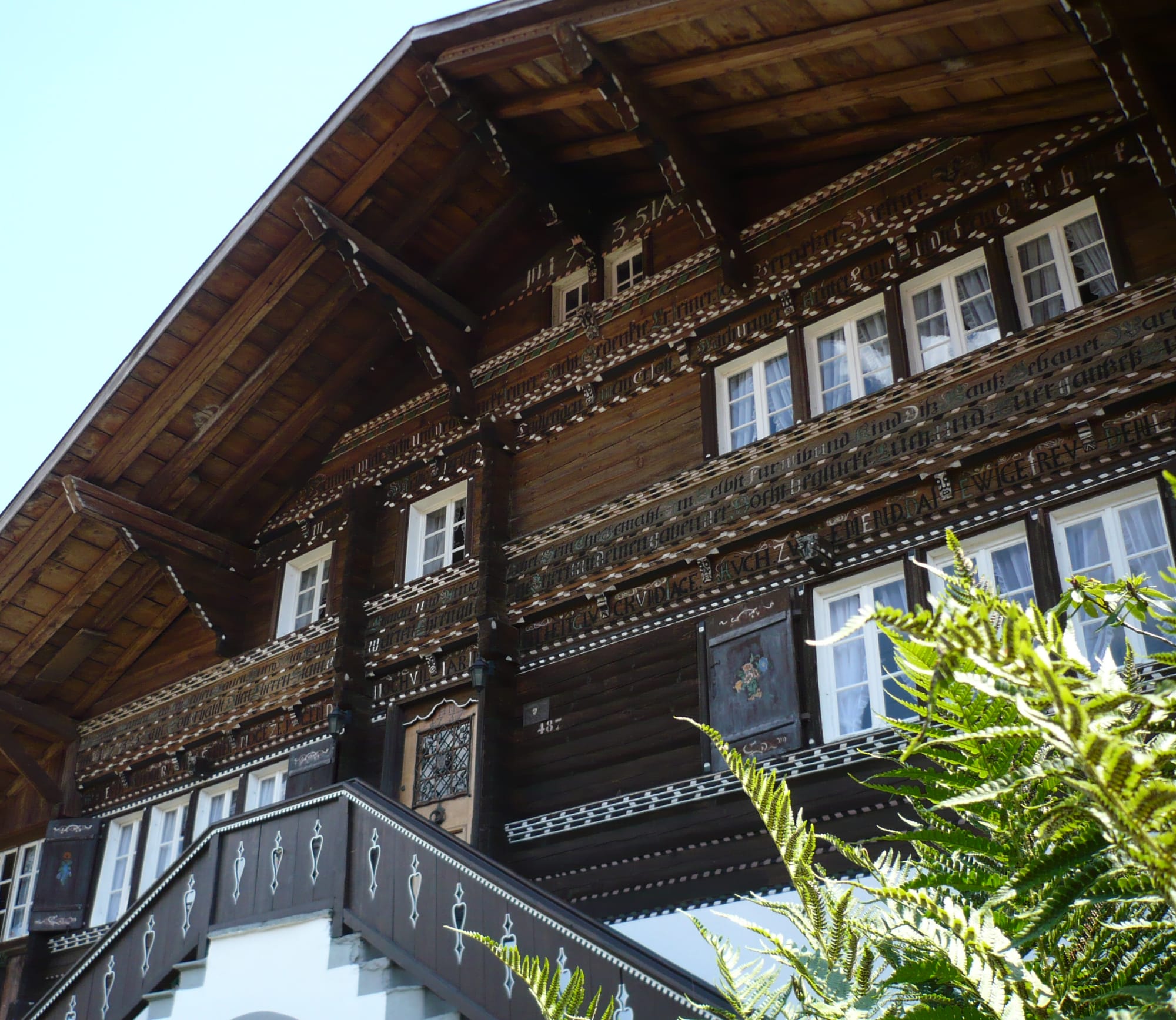 Traditionelles Schweizer Chalet mit Holzfassade, weissen Verzierungen und weissen Fensterrahmen